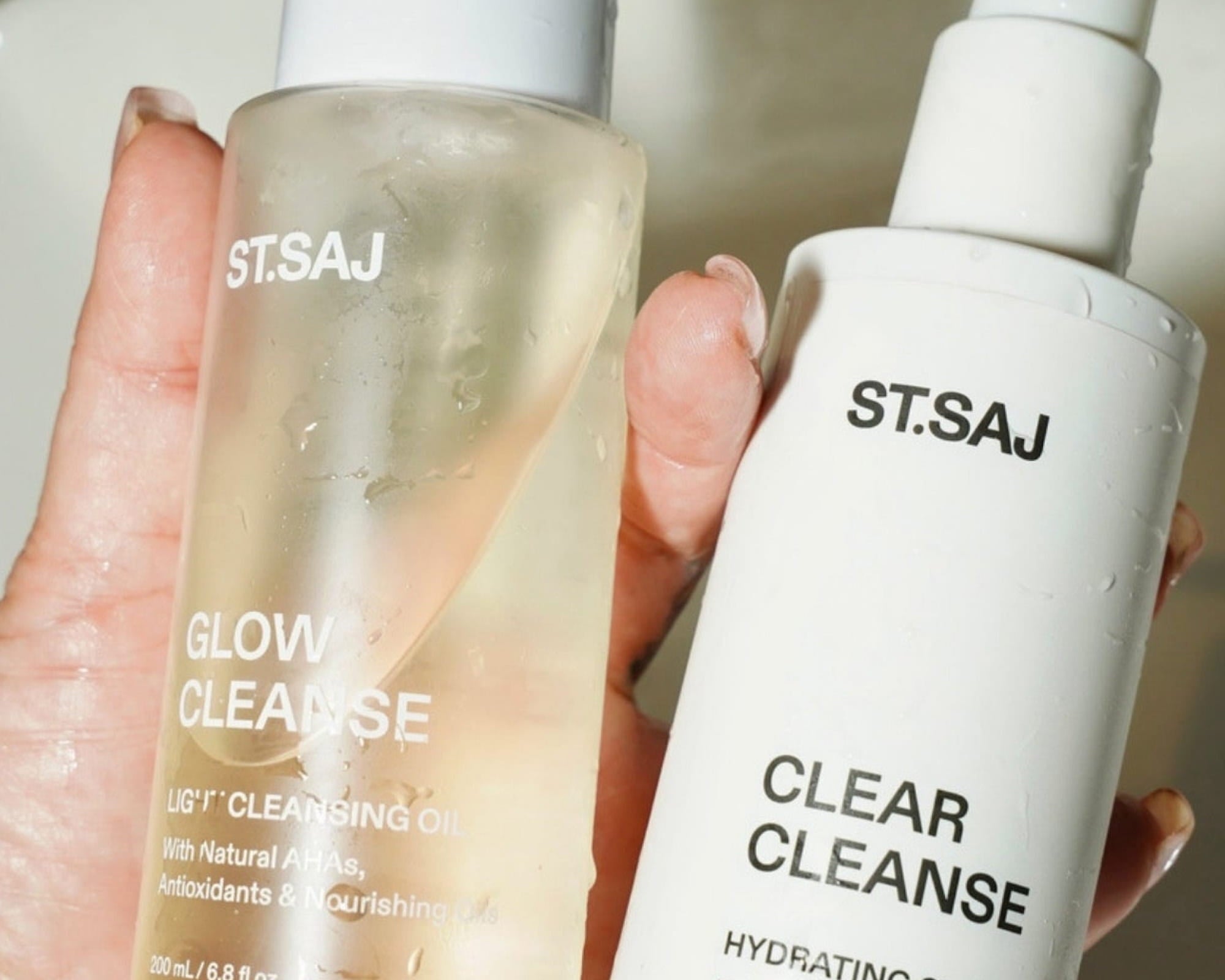 Hand holding ST.SAJ Glow Cleanse and Clear Cleanse double cleanse duo