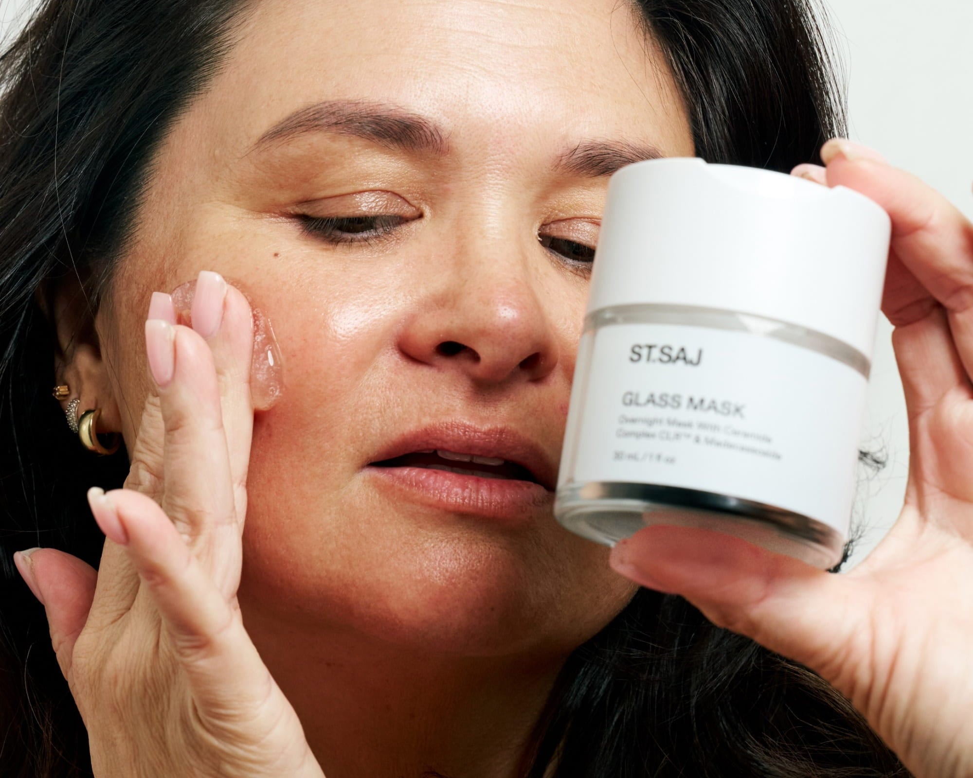 Emmylou with dewy glass skin holding ST.SAJ Glass Mask jar to her face