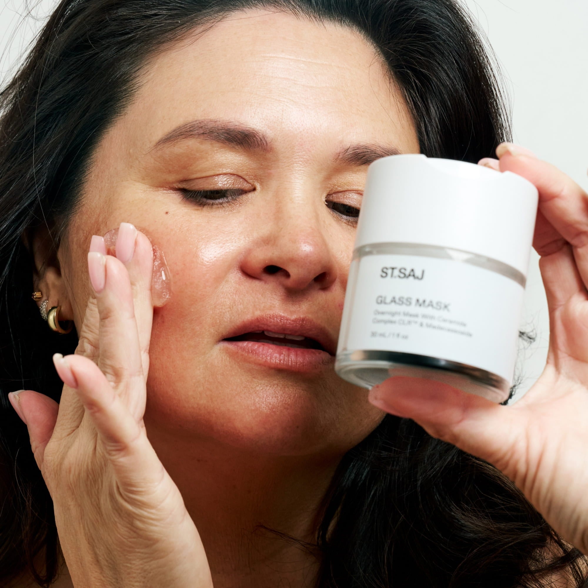 Emmylou with dewy glass skin holding ST.SAJ Glass Mask jar to her face