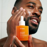 Man applying ST.SAJ Radiant Super C to his face, holding Radiant Super C