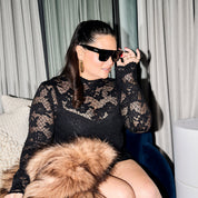 Emmylou in black lace dress wearing ST.SAJ Eyewear SS01 seated with fur wrap.
