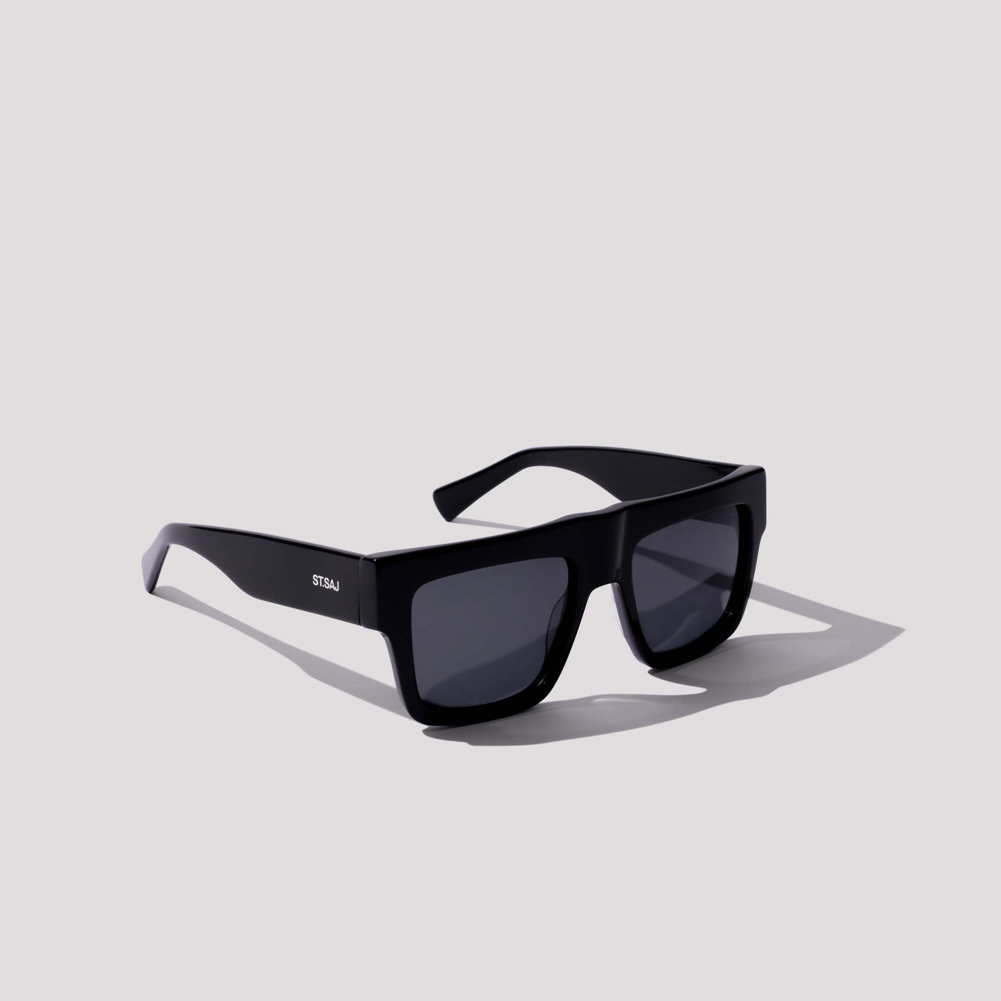 ST.SAJ Eyewear SS01 black oversized square sunglasses on grey background.
