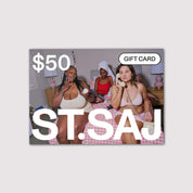 ST.SAJ $50 gift card with group of women in sleepwear on pink bedding.
