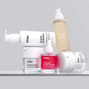 ST.SAJ Clear Skin Routine product group - Clear Cleanse, Peptide Power Essence, Supreme Skin 7, Niaglow Clarity Boost and Glass Mask on grey background.