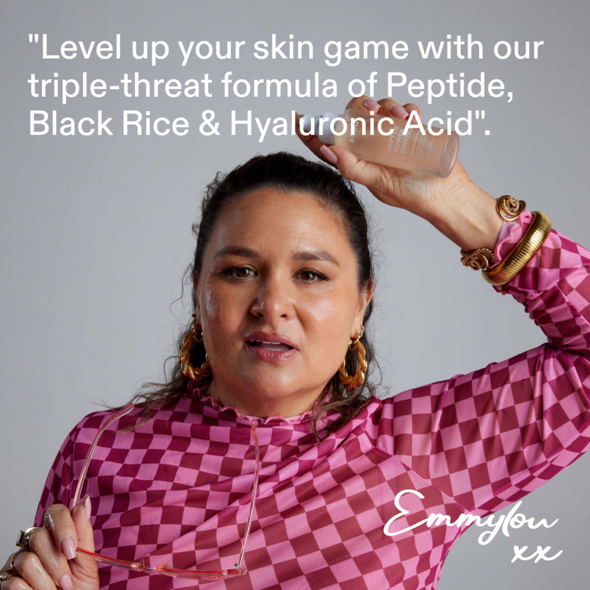 Founder Emmylou in pink checkered outfit, quote: level up your skin game with our triple-threat formula of Peptide, Black Rice & Hyaluronic Acid.