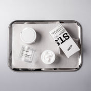 ST.SAJ Supreme Skin 7 and refill pouch on silver tray, overhead shot.