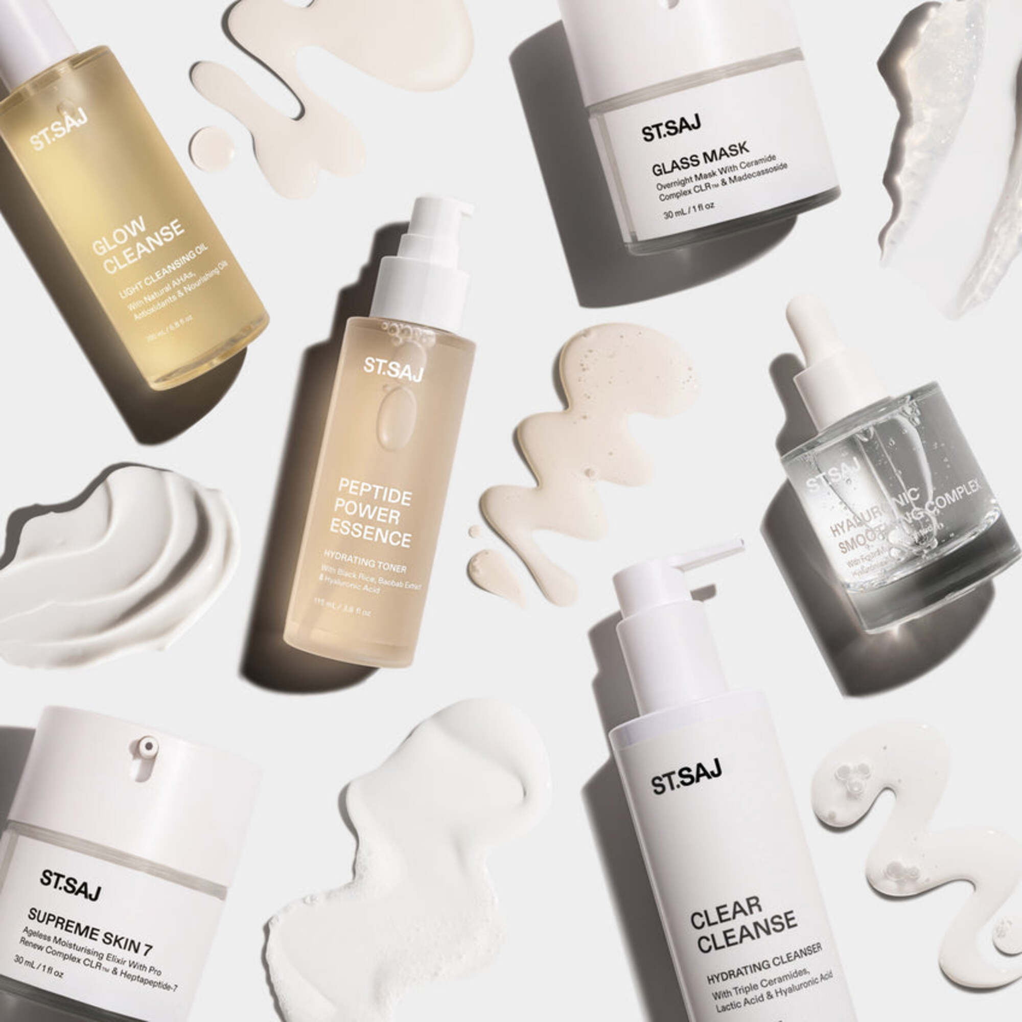 ST.SAJ Hydrate & Repair Kit flat lay - Glow Cleanse, Glass Mask, Peptide Power Essence, Hyaluronic Smoothing Complex, Supreme Skin 7 and Clear Cleanse with cream swatches on white background.