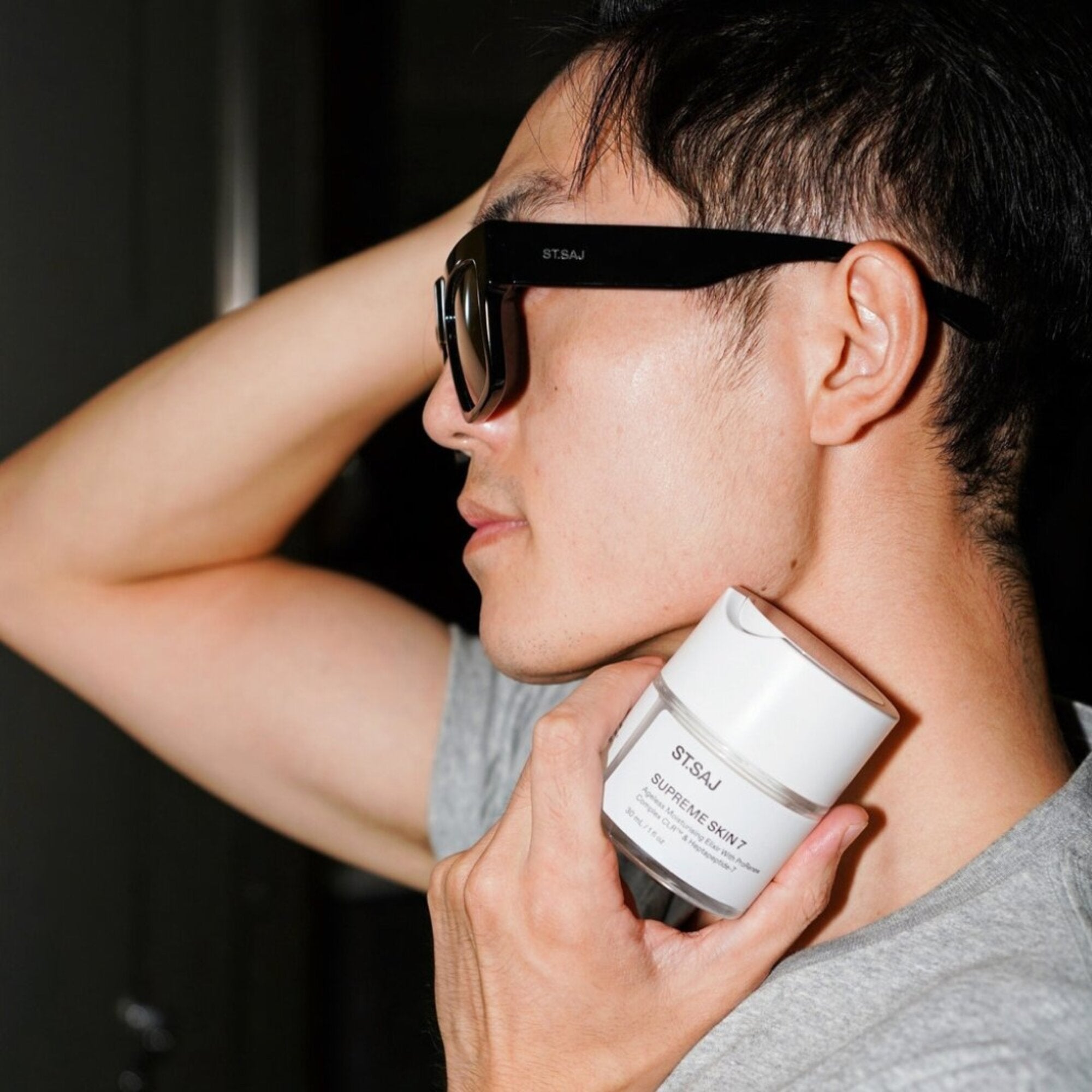 Man wearing ST.SAJ Eyewear SS01 holding SUPREME SKIN 7