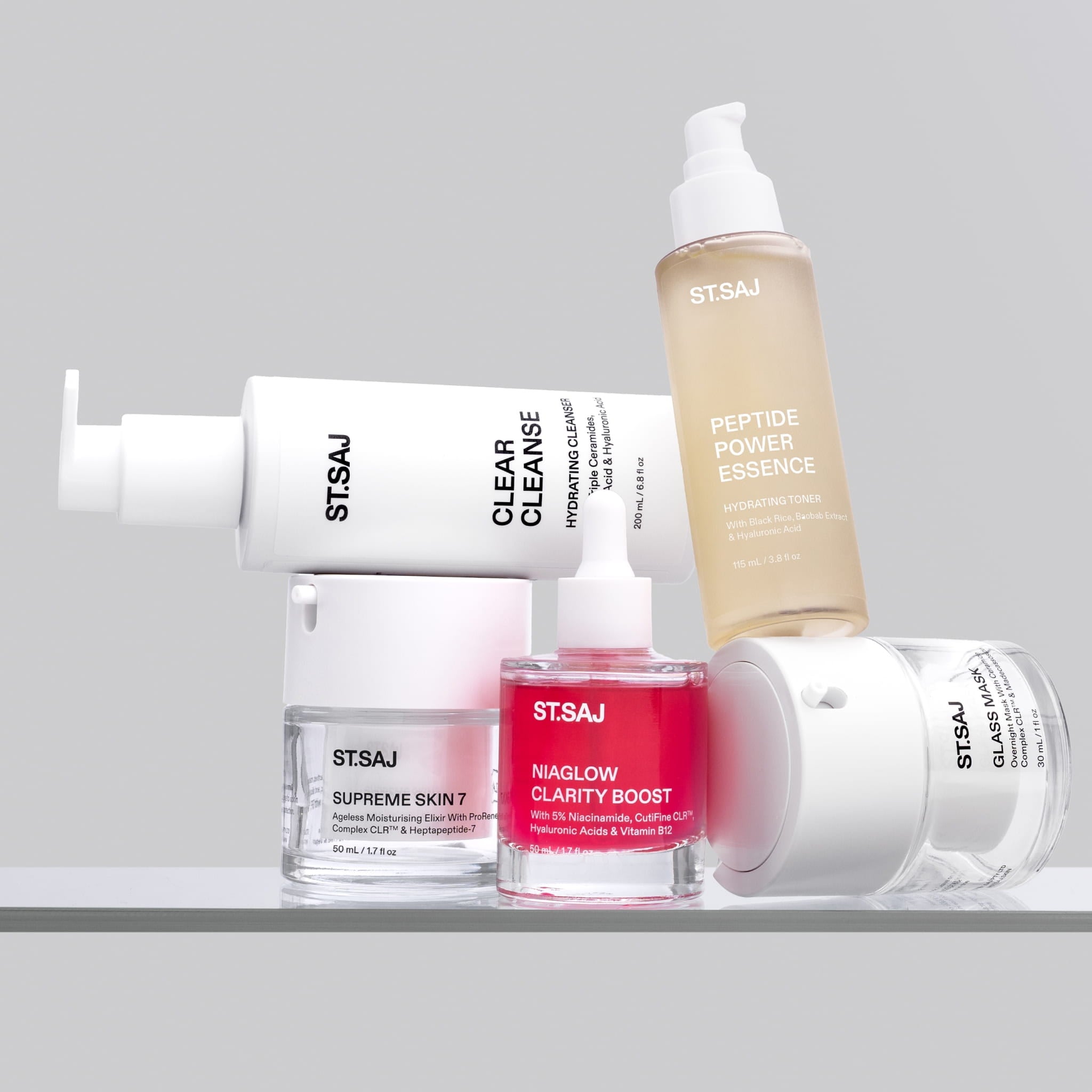 ST.SAJ Clear Skin Routine: Clear Cleanse, Peptide Power Essence, NiaGlow Clarity Boost and Supreme Skin 7 product flat lay

