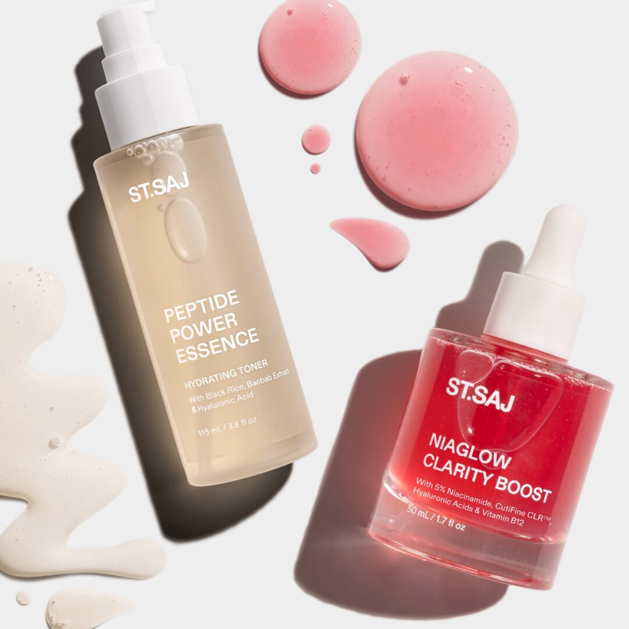 ST.SAJ Peptide Power Essence and Niaglow Clarity Boost laid flat with pink serum droplets on light background.