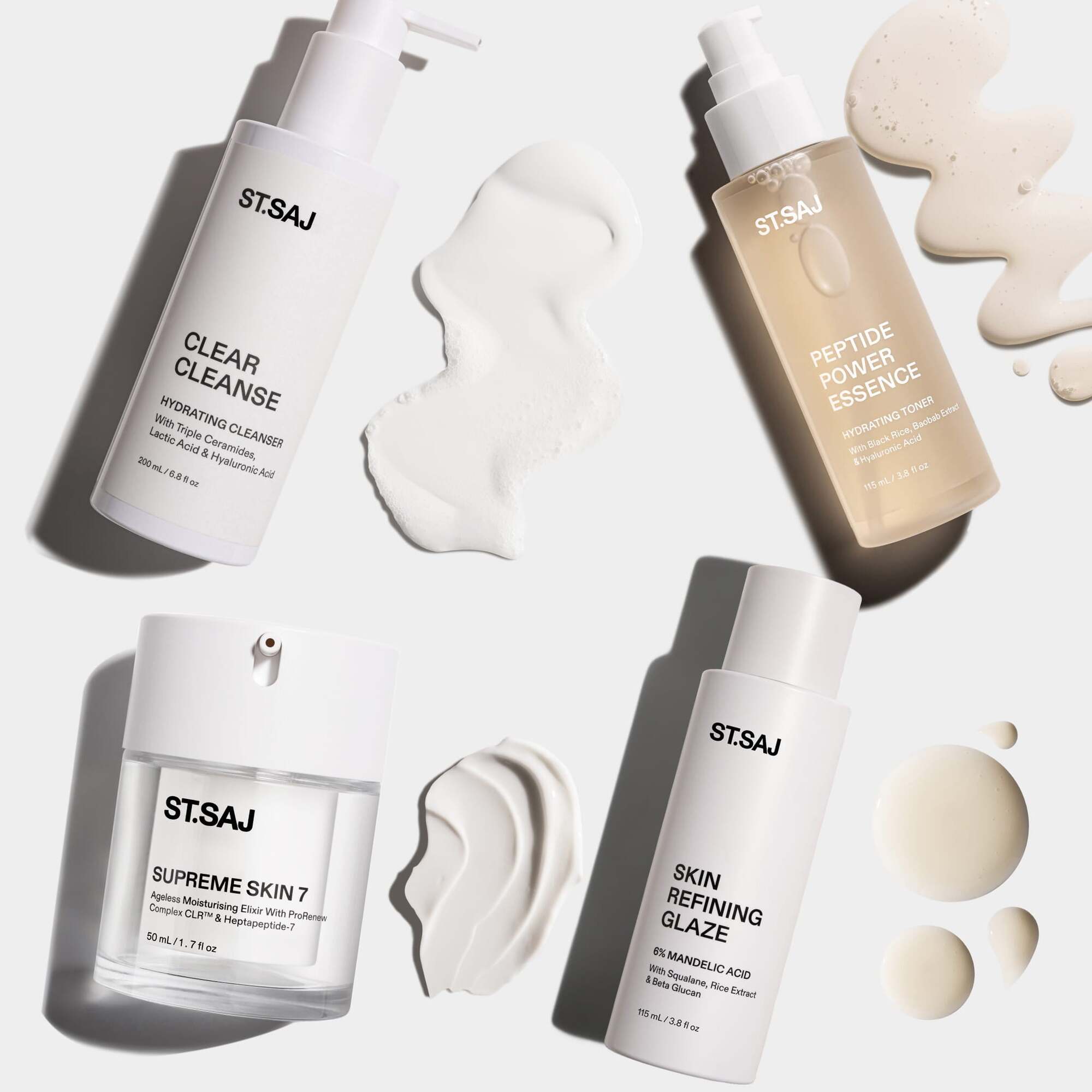 ST.SAJ Skin Refining Routine flat lay - Clear Cleanse, Peptide Power Essence, Supreme Skin 7 and Skin Refining Glaze with cream swatches on grey background.