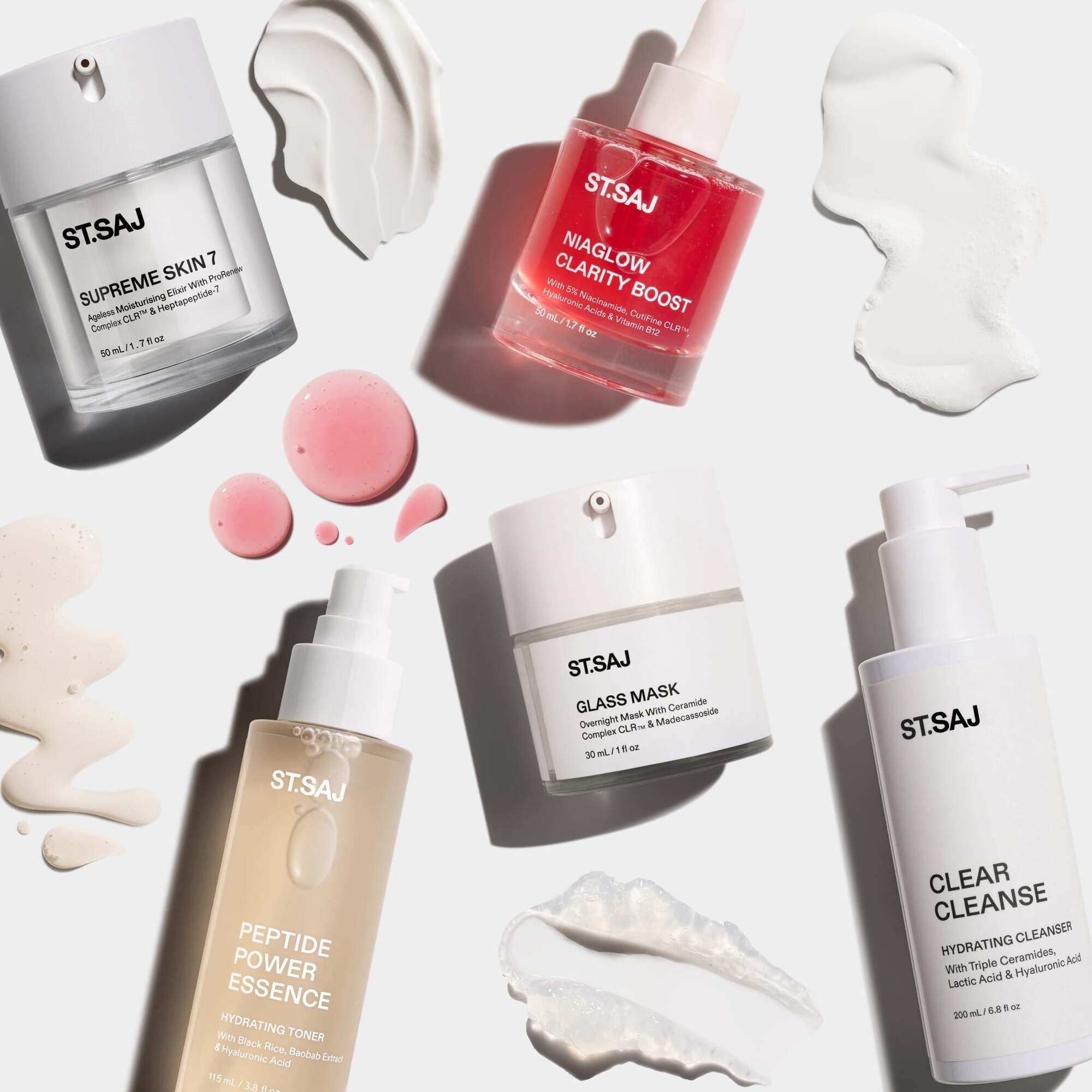 ST.SAJ Clear Skin Routine products with cream and gel swatches scattered on white background - Supreme Skin 7, Niaglow Clarity Boost, Glass Mask, Peptide Power Essence and Clear Cleanse.