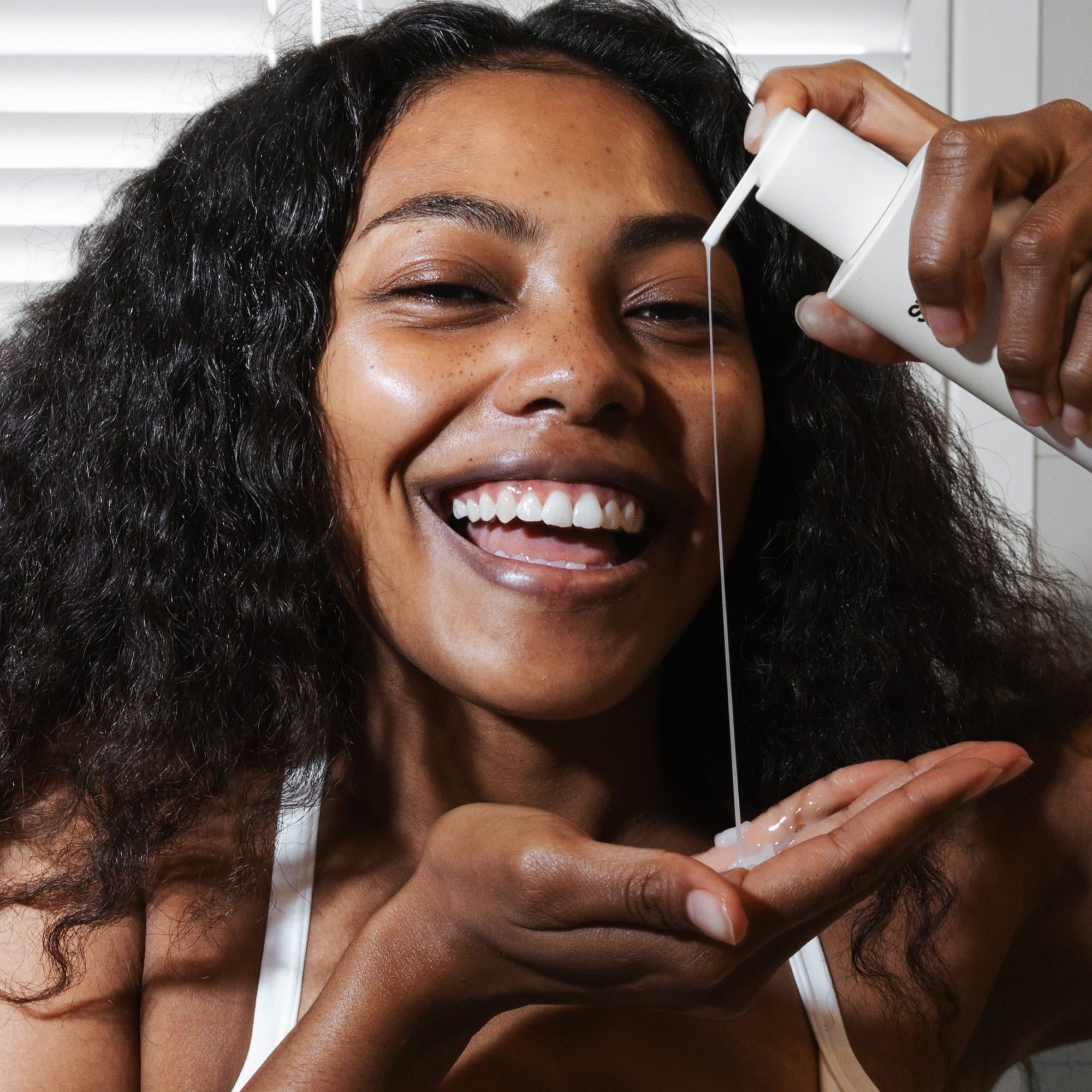 Smiling woman applying ST.SAJ Clear Cleanse hydrating face wash - gentle daily cleanser Australia
