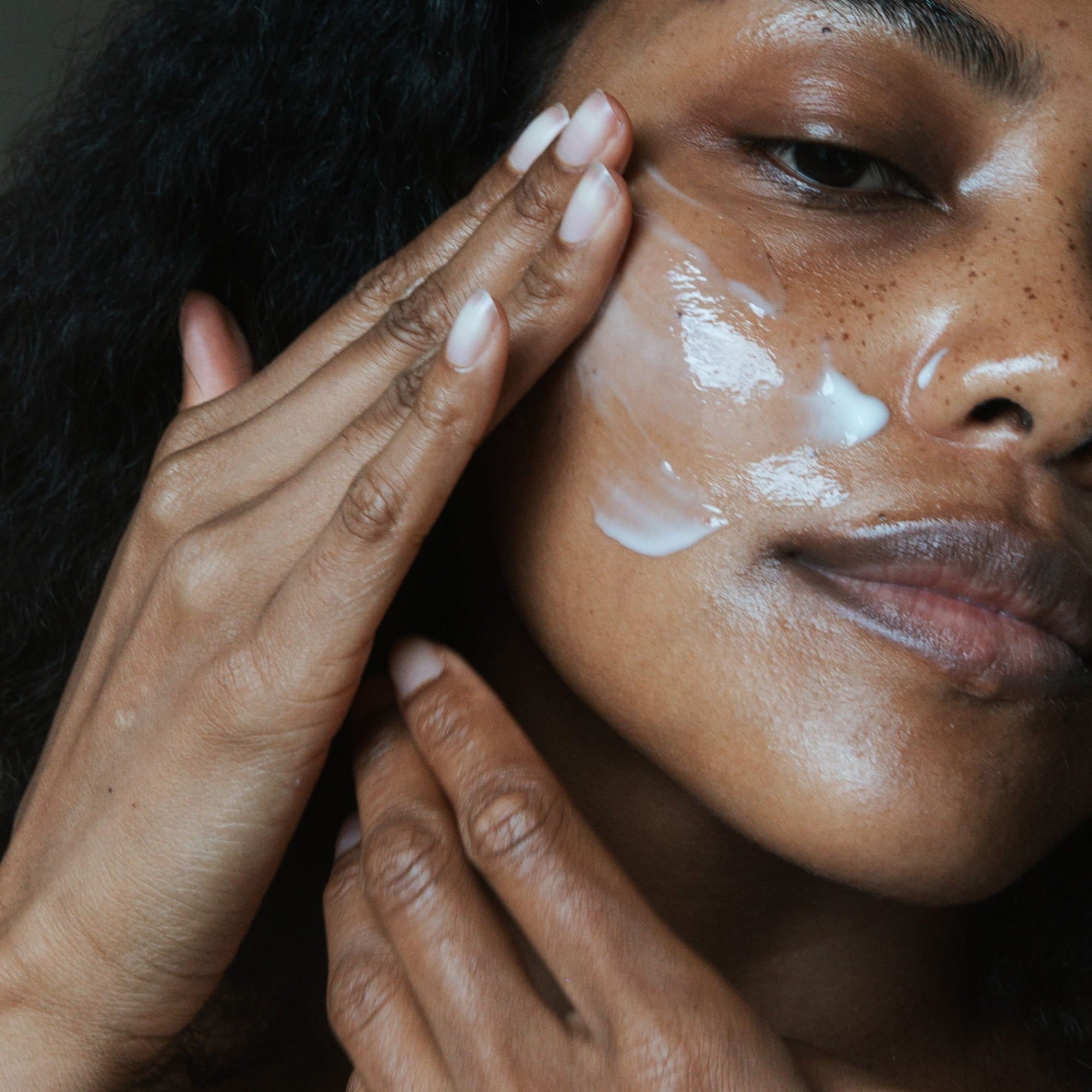 Close up of woman applying ST.SAJ moisturiser to cheek - barrier repairing skincare Australia