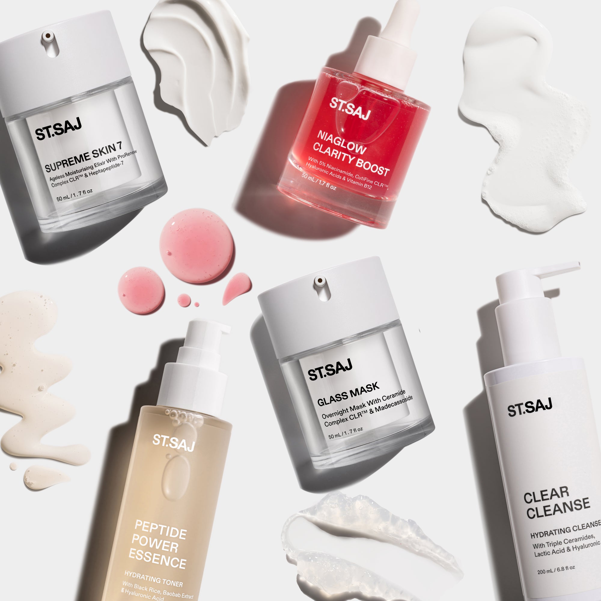 ST.SAJ Clear Skin Routine products with cream and gel swatches scattered on white background - Supreme Skin 7, Niaglow Clarity Boost, Glass Mask, Peptide Power Essence and Clear Cleanse.