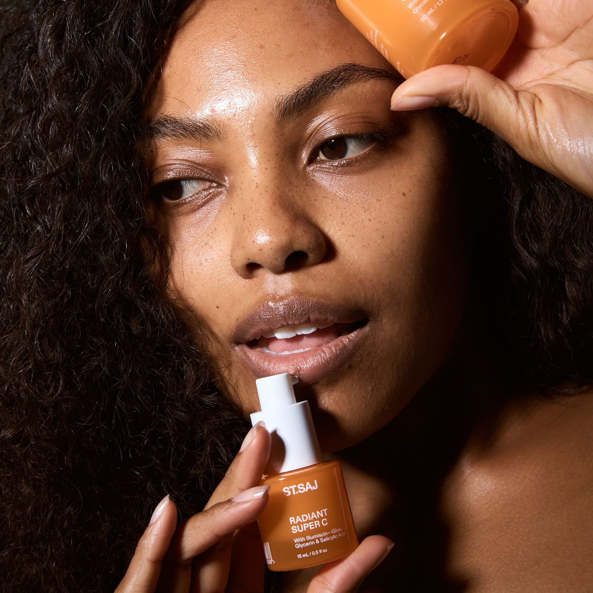Model applying ST.SAJ Radiant Super C serum to face
