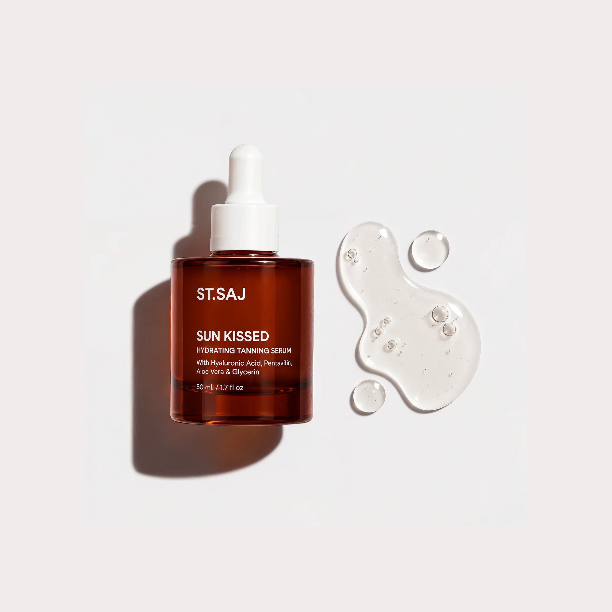 ST.SAJ Sun Kissed Hydrating Tanning Serum 50mL amber dropper bottle beside a clear serum texture swatch